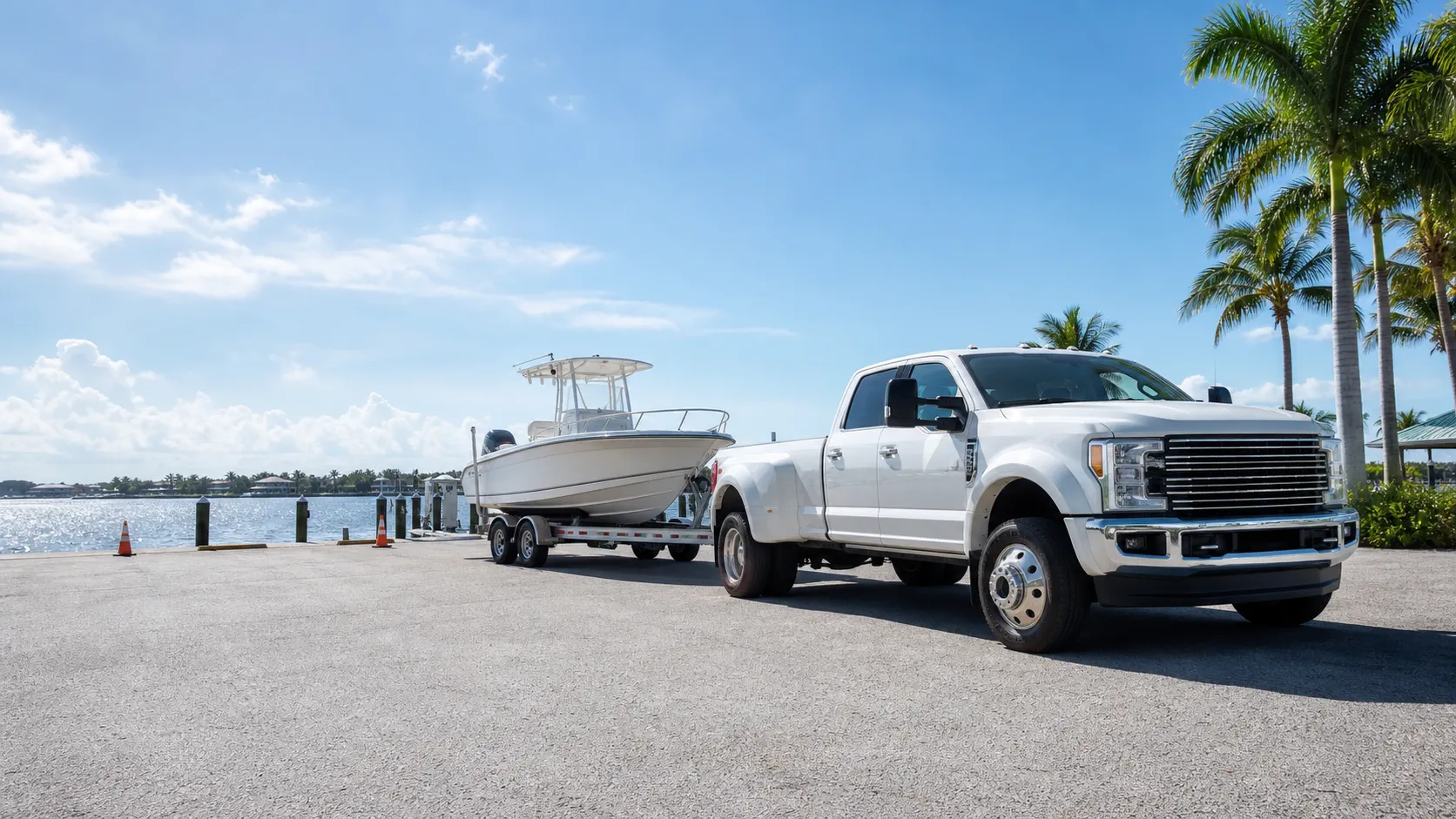 Truck towing a boat trailer near a marina